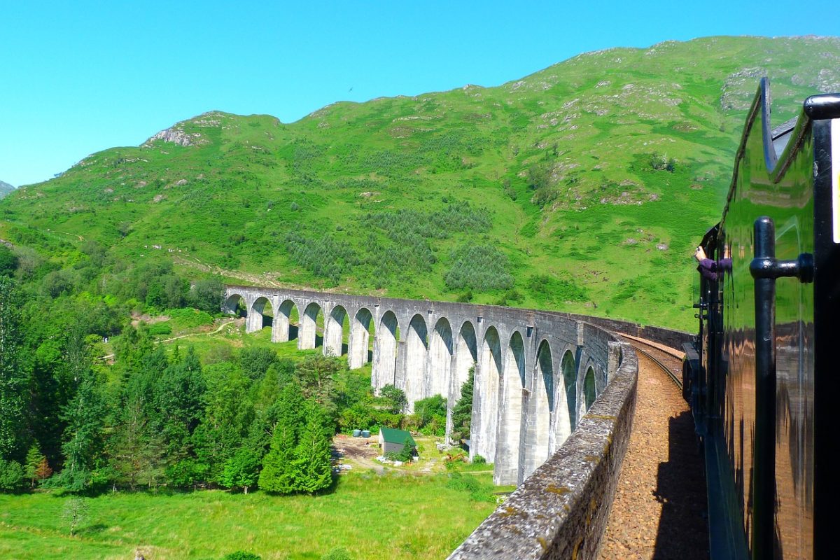 Die historische Eisenbahnbrücke, bekannt durch die Harry Potter-Filme, schlängelt sich durch die malerische Landschaft der schottischen Highlands.